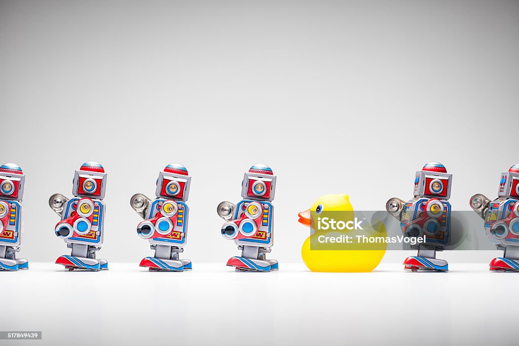 Standing out from the crowd - Tin Robot Rubber Duck Retro tin toy robots and a rubber duck standing in a row. Individuality Stock Photo
