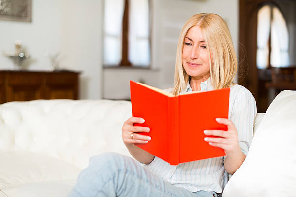 istock Mature woman reading a book 517850534