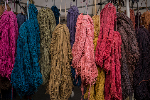 Bundles of colorful yarn hanging from ceiling in outdoor market, New York, USA 