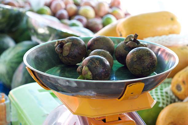 istock Fresh mangosteens on scale at fruit vendor in Phuket, Thailand 517853228