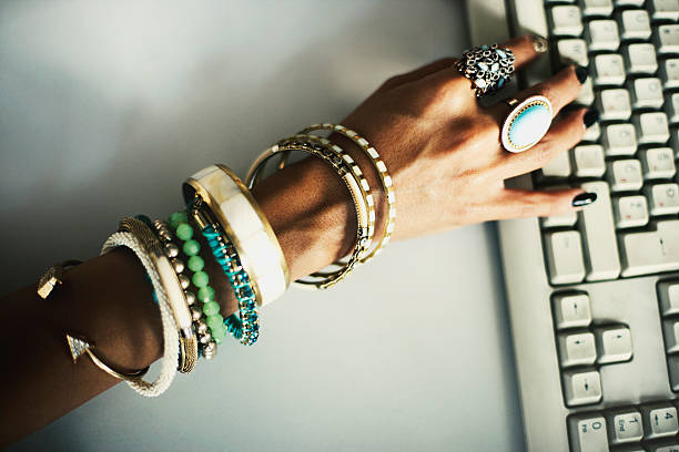 Artistic photo of hands with jewellery typing on keyboard