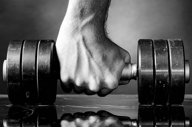 istock male hand is holding metal barbell 517853749