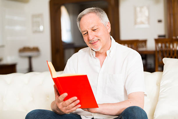 istock Happy mature man reading a book 517863234