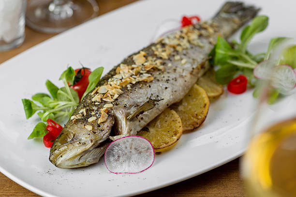 istock baked fish with lemon and almonds served 517867132