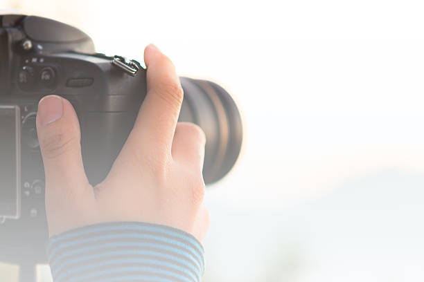 istock Photographer's hand on  DSLR camera focus at sunrise lanscape sc 517867194