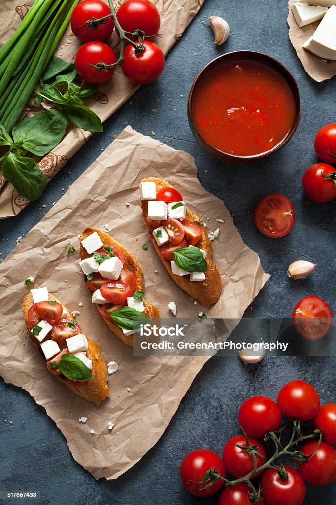 Bruschetta traditional Italian antipasti snack food Bruschetta traditional Italian antipasti snack food with roasted baguette tomatoes, feta, basil and garlic. Top view Antipasto Stock Photo