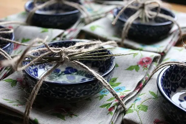 Sets of presents decorated with threads and herbs. Decorative plates wrapped with linen towels for presents.