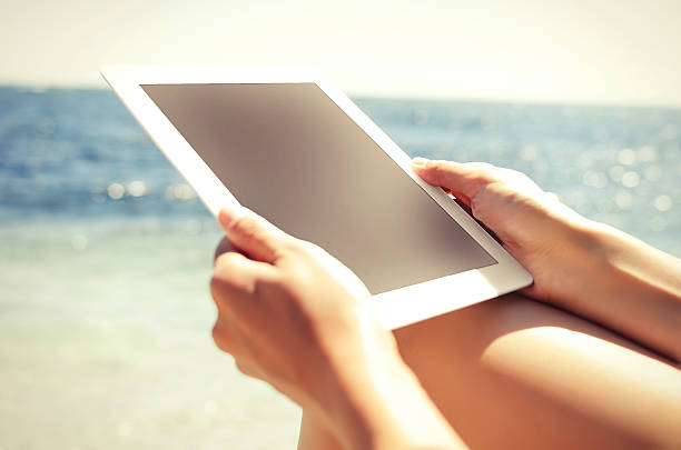 istock Woman with tablet pc at the beach 517869943