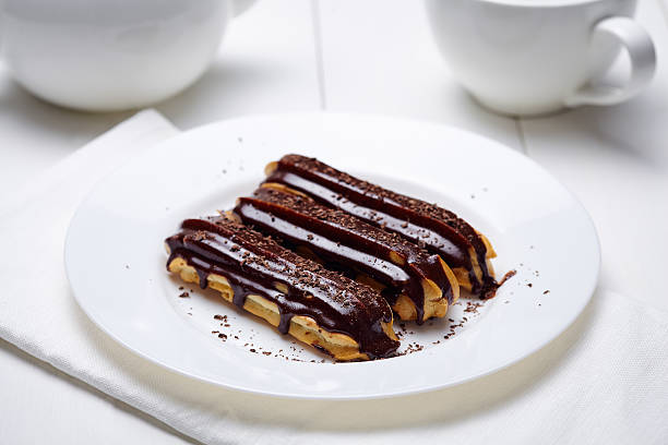 istock Traditional eclairs or profiteroles with chocolate icing and whipped cream 517869980