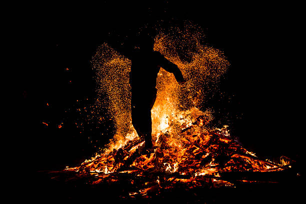 Sofia, Bulgaria - March 13, 2016:  Young man is jumping above the traditional fire during celebration of Sirni Zagovezni. It is believed that evil spirits are chased away with this fire rituals.