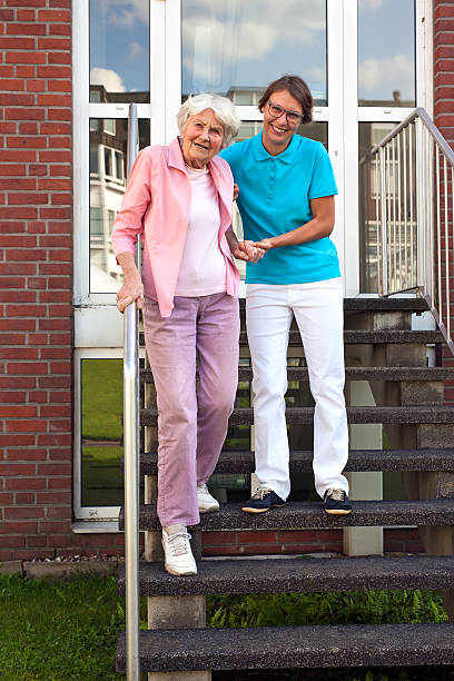 istock Friendly carer helping a senior lady on steps. 517870675