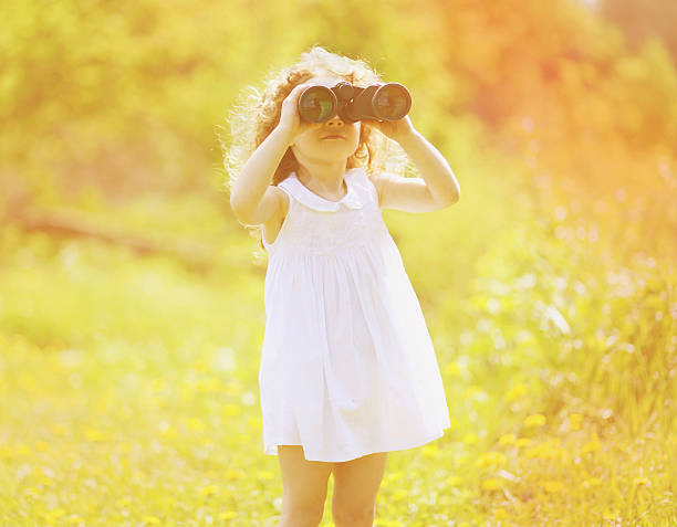 istock Child looks in binoculars on sunny summer day 517871425