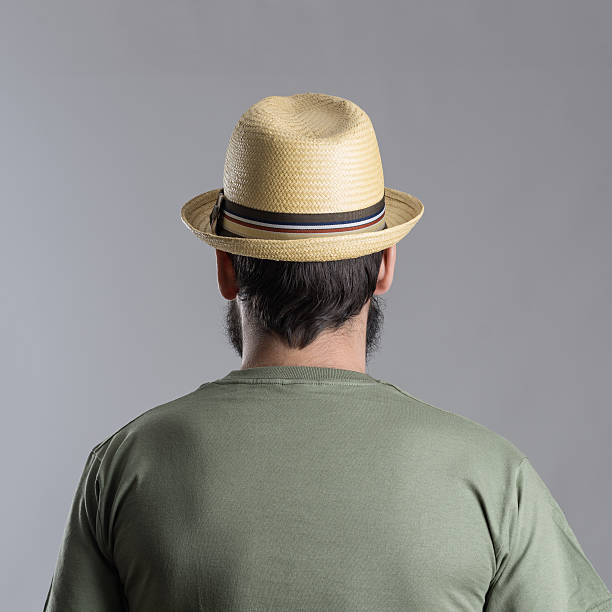 istock Back view of bearded man with straw hat looking away. 517871590