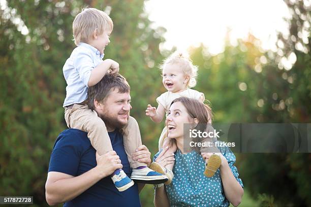 Kinder Reiten Auf Eltern Im Park Stockfoto und mehr Bilder von Junge Familie - Junge Familie, Familie mit zwei Kindern, Kind