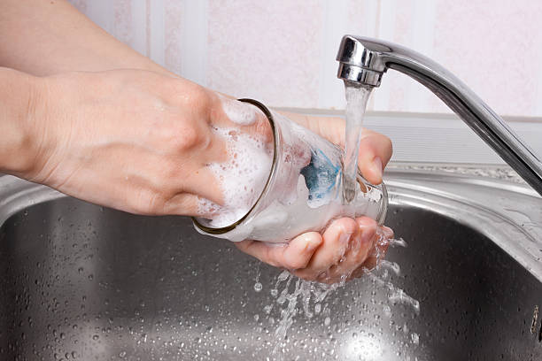 hands of woman washing the dishes hands of woman washing the glass in sink washing dishes photos stock pictures, royalty-free photos & images