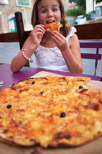 istock Girl eating Pizza 517874263