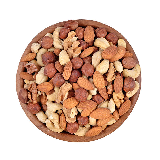 istock Assorted nuts in a wooden bowl on a white background 517875131