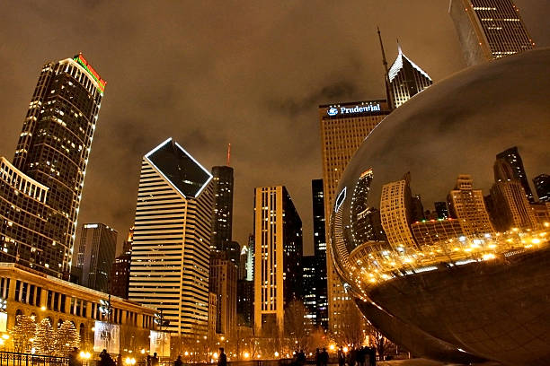 Chicago lights Chicago, Illinois, USA - December, 23, 2012. The lights of skyscrapers reflected in Cloud Gate, Millennium park. millennium park chicago stock pictures, royalty-free photos & images