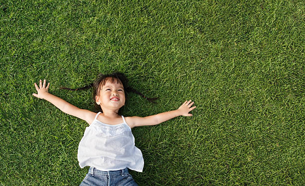 little girl lay on grass stock photo