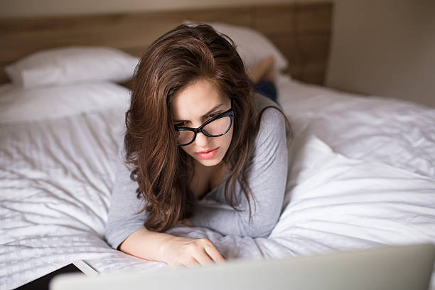 istock Woman lying on the bed, using a laptop 517877020