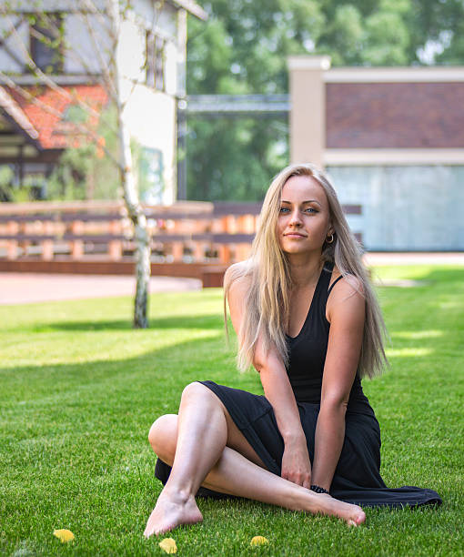istock Blonde model sitting on the grass 517877081
