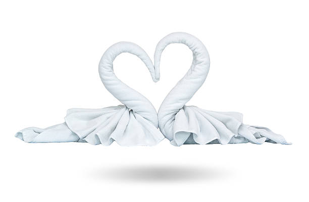 Two white towels swans with heart on white background