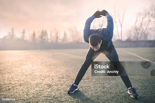 Photo libre de droit de Bel Athlète Séchauffer Avant De Jogging banque d'images et plus d'images libres de droit de Froid - Froid, S'étirer, Automne