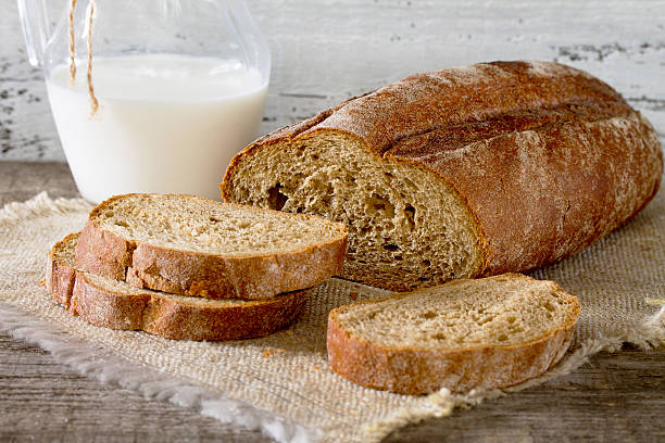 istock Fresh bread slices and milk in a rustic style 517892746