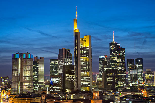 The modern edifice of the European Central Bank overlooking the River Main and the glittering skyscrapers of the financial district in the heart of Frankfurt, Germany.