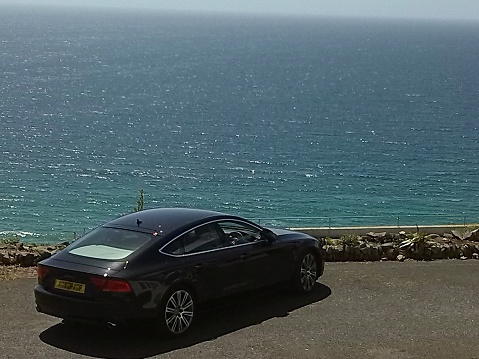 Mousehole, Cornwall, UK - July 11, 2015: A car is parked on a cliff face on a sunny summer's day