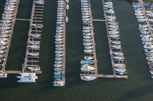 An overhead photograph of a dock or slip mostly full of boats and sailboats.  