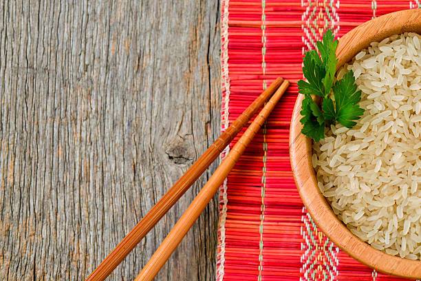Bowl with brown uncooked rice and leaf of parsley