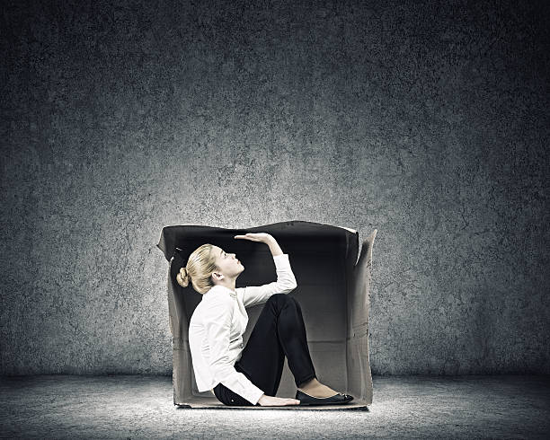 Girl in box Young businesswoman trapped in carton box trap stock pictures, royalty-free photos & images