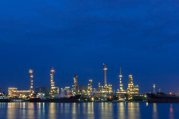 istock Oil refinery beside a river during twilight 517895503