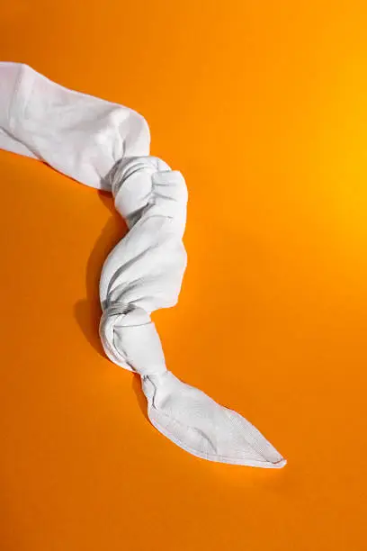 Photo of Hanky with two knots on an orange background