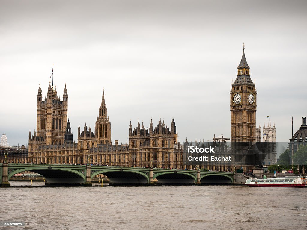 Palace of Westminster with Elizabeth Tower and Big Ben The Palace of Westminster with the Elizabeth tower, Big Ben and Westminster bridge seen from the south bank of the river Thames on a gloomy, cloudy day with overcast sky. Abbey - Monastery Stock Photo