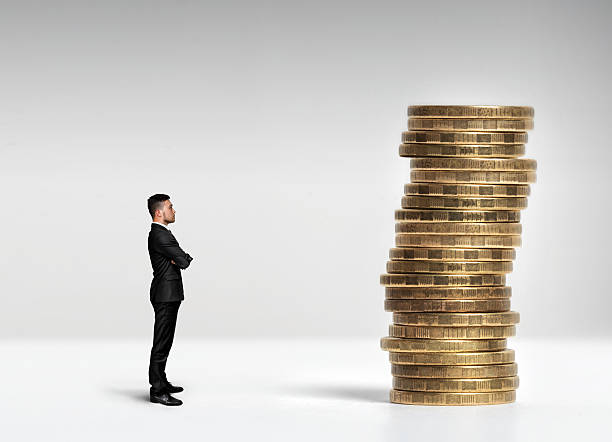 istock Businessman standing in front of a stack scale rouble coins 517897366
