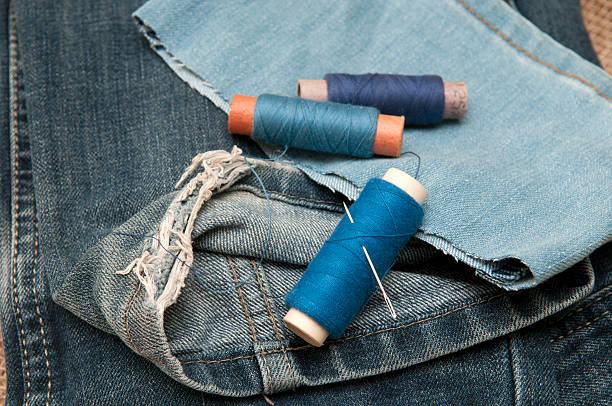 istock Old torn jeans on a background of burlap. 517897464