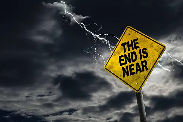 End is Near sign against a stormy background with lightning and copy space. Dirty and angled sign adds to the drama.