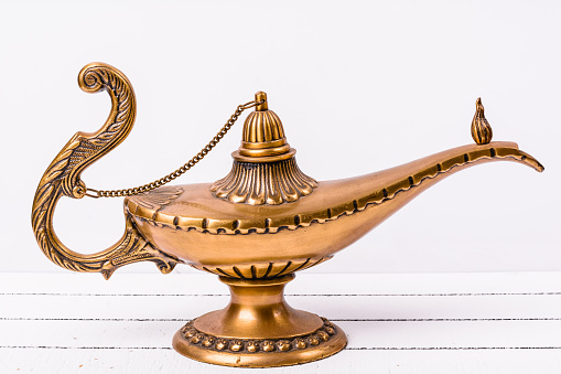 Aladdin magic lamp on light wooden background