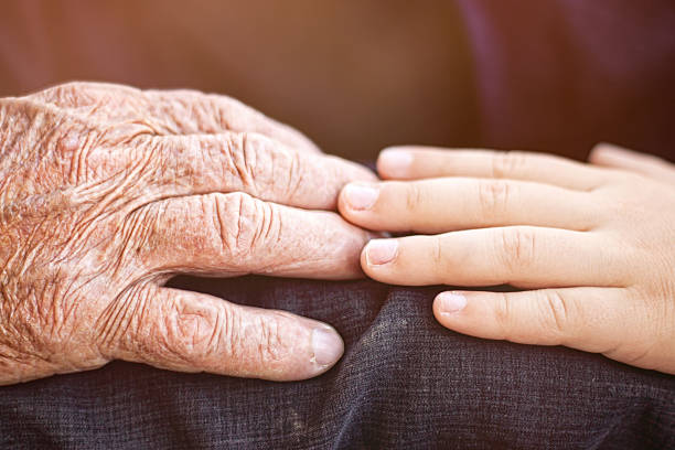 istock nephew touching grandfather's hand 517901458
