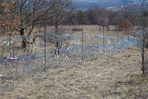 Razor wire barbed chain link fence barrier against uncontrolled coming of Middle Est refuges. It is on border between Slovenia and Croatia