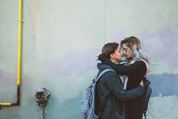 istock Lesbian couple embracing on back street 517903092