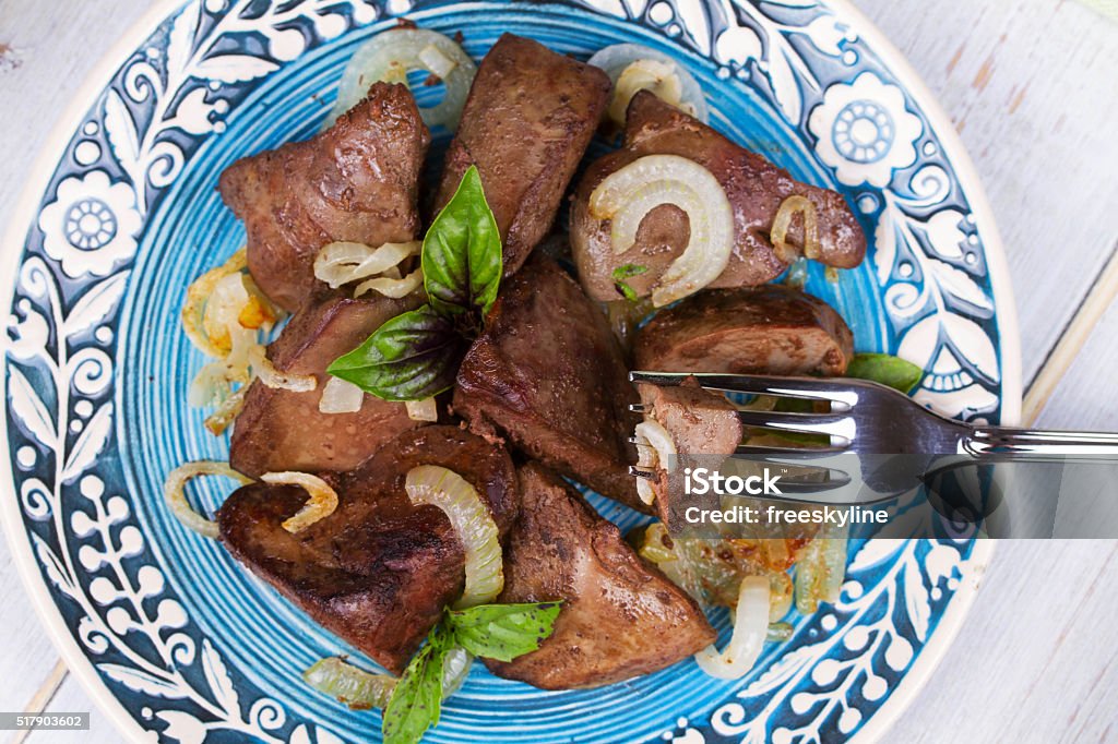 Sautierte Gänseleber mit Zwiebeln auf blau Platte - Lizenzfrei Leberfleisch Stock-Foto