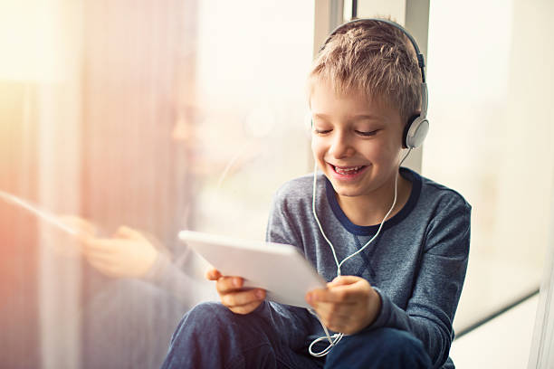 istock Happy little boy using tablet with headphones 517904104