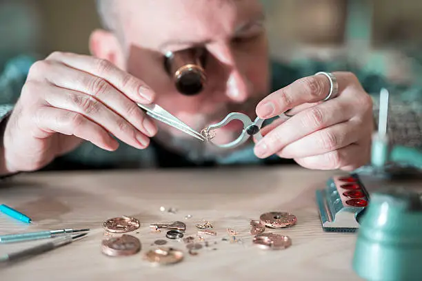 Close up portrait of a watchmaker at work.Old pocket watch being repaired by watch maker.