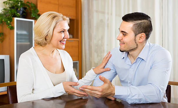 istock Young man and aged woman talking indoor 517905110