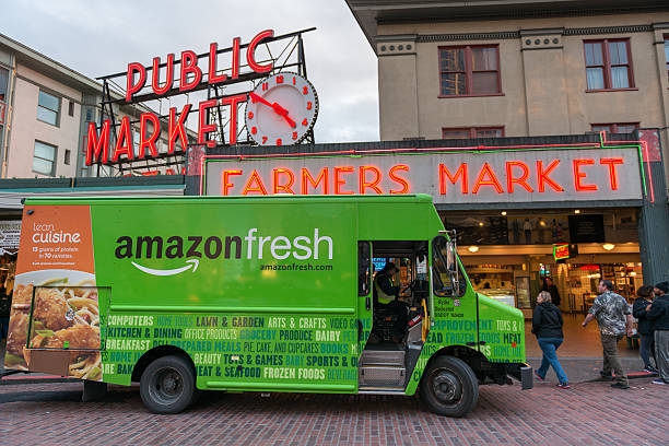 Amazon Fresh Seattle, USA - February 2, 2016: An Amazon Fresh truck in front of the famous Pike Place Market late in the day. elliott bay photos stock pictures, royalty-free photos & images