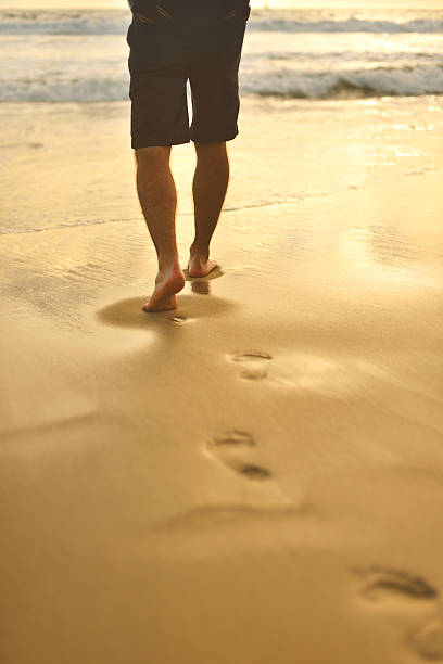 istock Young man walking on the beach 517924141
