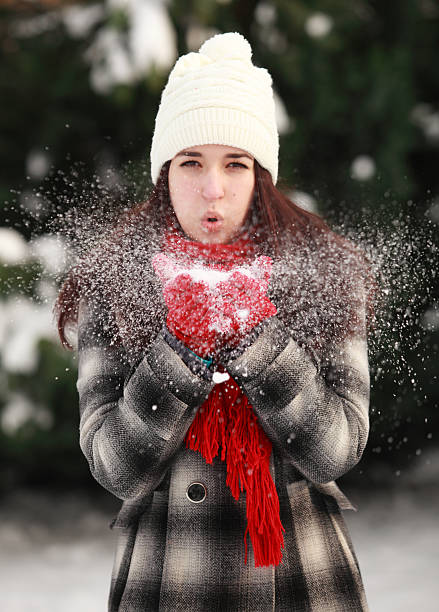 istock Young beautiful woman blowing snow in winter 517924347